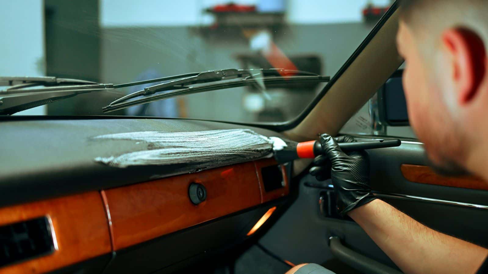 Dashboard van een auto wordt met een kwastje gereinigd