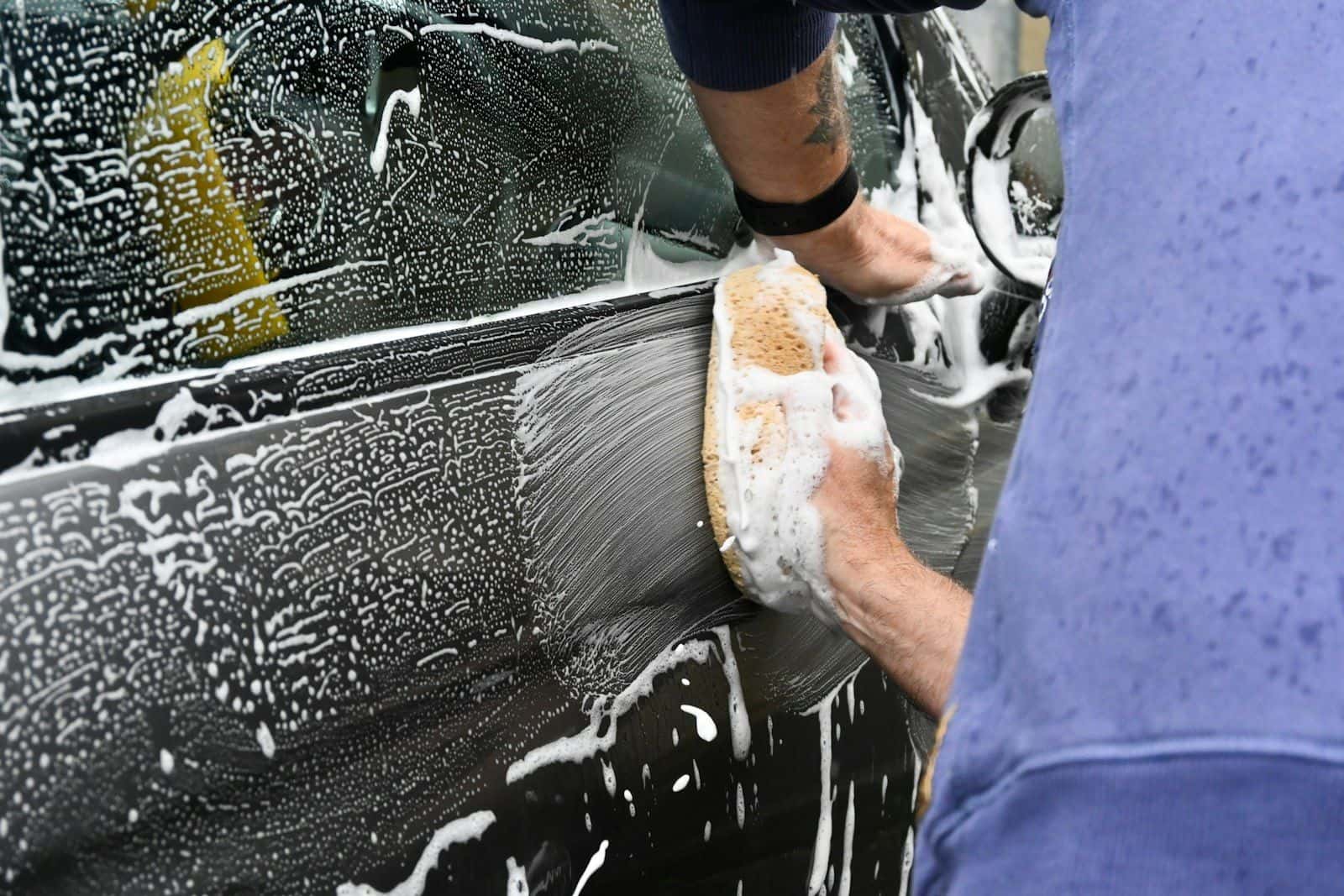 Auto wordt met een spons en zeepsop gewassen